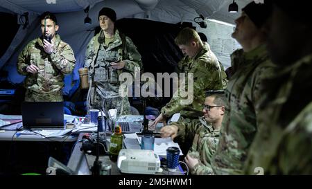 Fallschirmjäger aus dem 1. Bataillon, dem 501. Infanterie-Regiment, dem 4. Infanterie-Brigaden-Kampfteam (Airborne), der 25. Infanterie-Division, der „Spartanischen Brigade“, führen im taktischen Operationszentrum im Rahmen des Joint Pacific Multinational Readiness Center 22-02 am 18. März 2022 einen aktuellen Stand der Schlacht durch. Das in JPMRC 22-02 verwendete „Near-Peer“-Szenario unterstützt Soldaten und Führer bei der Entwicklung und Verfeinerung der Taktiken, Techniken und Verfahren, die erforderlich sind, um unter abgelegenen und extremen arktischen Winterbedingungen erfolgreich zu operieren und sowohl ökologische als auch militärische Herausforderungen zu bewältigen Stockfoto