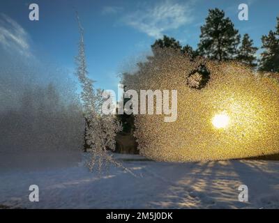 Frost und Sonne am morgendlichen Winterfenster Stockfoto