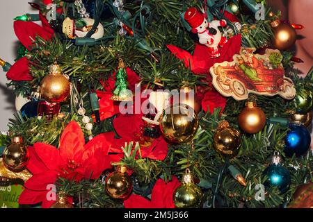 Kleiner künstlicher weihnachtsbaum, dekoriert mit Ornamenten und Lichtern Stockfoto