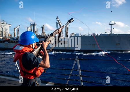 PHILIPPINE SEA (18. März 2022) Gunner’s Mate Seaman Apprentice Ai’Jai Schultz aus Savannah, Georgien, feuert eine Schusslinie ab vom Arleigh-Burke-Class-Guided-Raketenzerstörer USS Dewey (DDG 105) bis zum militärischen Sealift-Kommando-Flottenauffüller USNS John Ericsson (T-Sea-Wiederauffüllung) während A O 194-AT-A. Dewey ist der Destroyer-Staffel (DESRON) 15 zugeteilt und unterstützt derzeit ein freies und offenes Indo-Pacific. CTF 71/DESRON 15 ist die größte nach vorn verlegte DESRON-Flotte der Marine und die größte Oberflächenkraft der US-7.-Flotte. Stockfoto