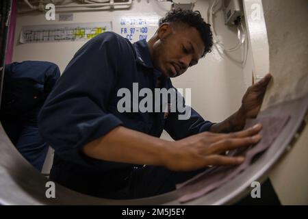 220318-N-VS068-1026 PAZIFIK (18. März 2022) – Information Systems Technician 3. Class Quentin Corpuz-McGrady sandet eine Passage an Bord des Amphibienschiffs USS Makin Island (LHD 8), März 18. Makin Island führt Routineeinsätze in der US-3.-Flotte durch. Stockfoto