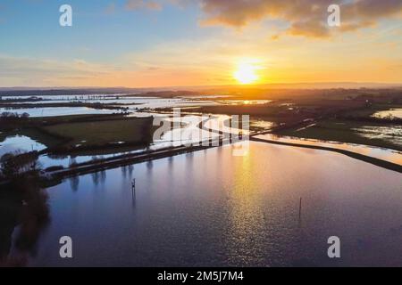 Muchelney Somerset, Großbritannien. 29. Dezember 2022 Wetter in Großbritannien. Blick aus der Luft der überschwemmten Felder auf den Somerset-Ebenen bei Sonnenuntergang im Muchelney in Somerset, nachdem die River Parrett nach starkem Regen ihre Ufer zerbrach. Bildnachweis: Graham Hunt/Alamy Live News Stockfoto