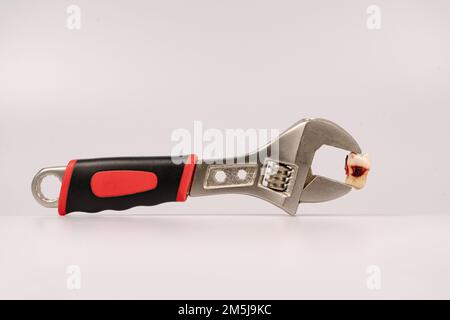 Zahnextraktion mit Zahnwerkzeugen bei Karies durch einen Stamatologen in einer Zahnarztpraxis. Eine Zange mit einem Weisheitszahn. Zahnärztliches Konzept Stockfoto