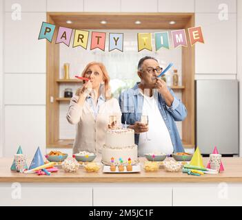 Reife Männer und Frauen bereiten eine Party vor und posieren in einer Küche Stockfoto
