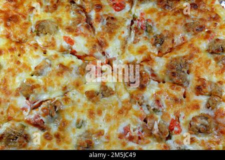 Italienische Pizza garniert mit Mozzarella-Käse und Garnelen, Tomaten und Gemüse, italienische Küche mit Scheiben Pizza, Meeresfrüchte-Garnelen, die serviert werden Stockfoto