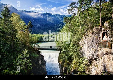 Wanderer überqueren eine Brücke über die Lech-Fälle auf dem Fluss Lech bei Füssen. Stockfoto