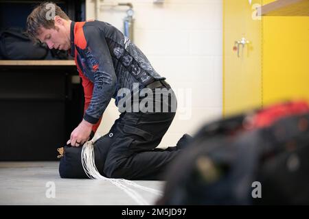 Master Sgt. Luke Whittington, ein Fallschirmspringer des United States Army Special Operations Command Fallschirmteams, The Black Daggers, packt seinen Fallschirm nach einem Sprung auf der Joint Reserve Base New Orleans der Naval Air Station, 19. März 2022 wieder ein. Die Black Daggers eröffneten die NAS JRB New Orleans Air Show und sprangen in diesem Jahr in eine besondere Flagge, um dem 80. Jahrestag des 377. Theater Sustainment Command zu gedenken. Es ist das größte Kommando im Armeereservat, das Nachhaltigkeitstruppen auf der ganzen Welt einsetzt. Stockfoto