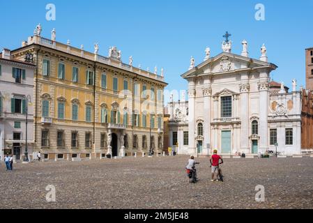 Radurlaub, Blick im Sommer auf ein erfahrenes Fahrradpaar, das auf der Piazza Sordello in Mantua pausiert, um die barocke Fassade des Doms in Italien zu erkunden Stockfoto