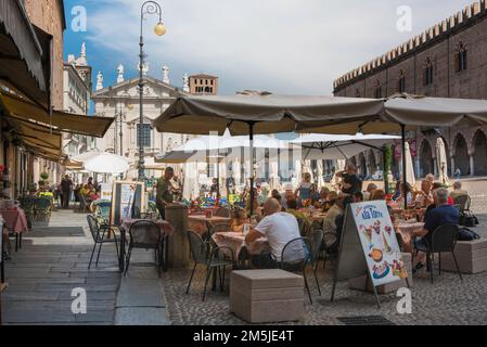 Italiener Straßencafé, Blick im Sommer auf die Menschen, die an Cafetstischen auf der Piazza Sordello sitzen, einem malerischen Renaissance-Platz in Mantua, Lombardei, Italien Stockfoto