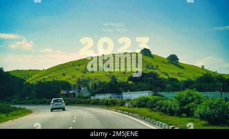 2023 Happy New Year Naturkonzept. Text 2023 geschrieben auf dem Berg und auf der Straße bei Sonnenuntergang. Konzept von Planung, Ziel, Herausforderung, Neujahrsresoluti Stockfoto