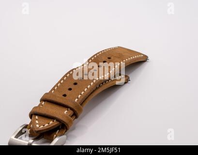 Detaillierte Nahaufnahme einer alten Armbanduhr aus Kamelholz aus Eichenleder mit Stift und Schnalle aus gebürstetem Edelstahl Stockfoto
