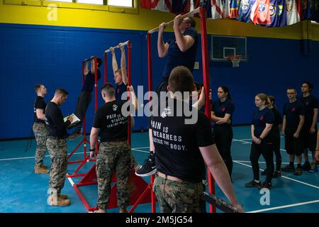 Poolees von Recruiting Station Pittsburgh absolvieren den Pull-up-Teil des anfänglichen Krafttests während der jährlichen Reserve Pool Function in Erie, Pennsylvania, 19. März 2022. Die zukünftigen Marines wurden zusammengebracht, um sich sowohl körperlich als auch geistig auf das Rekrutierungstraining vorzubereiten, indem sie den ersten Krafttest absolvierten und sowohl mit aktiven Dienst- als auch Reservemannschaften sprachen Stockfoto