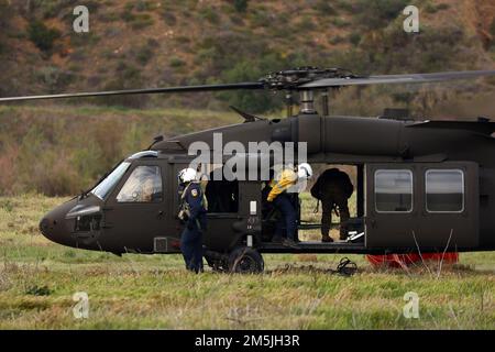 Zwei militärische Helikopter-Manager des California Department of Forestry and Fire Protection verlassen einen US-Bundesstaat Army UH-60m Black Hawk Hubschrauber geflogen von Soldaten des 1. Angriffs-Helikopter-Bataillons, 140. Luftfahrtregiment, California Army National Guard, während einer Flugausbildung zur Wildland-Brandbekämpfung mit dem California Department of Forestry and Fire Protection, 19. März 2022, in Silverado, Kalifornien. CAL Guard und CAL FIRE haben eine jahrzehntelange Partnerschaft bei der Bekämpfung der größeren Waldbrände in Kalifornien. Stockfoto