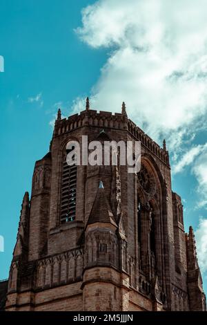 Ein kleiner Winkel der Kirche des Heiligen Namens von Jesus auf der Oxford Road, Manchester, mit einem wolkigen Himmel im Hintergrund Stockfoto