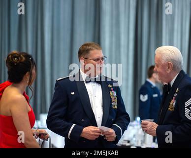 USA Oberstleutnant Jason Hull, Befehlshaber des 133. Sicherheitsgeschwaders, Center, spricht mit Chief Master Sgt. A. J. Langer, Senior Enlist Advisor für den 133. Airlift Wing von 1997 bis 2000 in St. Paul, Minn., 19. März 2022. The Hull und Long gehörten zu den mehr als 475 Flugzeugen und Gästen, die sich in Union Depot versammelten, um den 100. Jahrestag des 133. Luftwaffenflügels zu feiern, der am 17. Januar 1921 die erste staatlich anerkannte Einheit der Air National Guard im Land wurde. Stockfoto