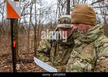 USA Army Sgt. 1. Class Rodney Brough, Right, und Sgt. 1. Class Larry May, Left, beide Ausbilder von Kompanie B, 4. Bataillon, 399. Regiment, sehen Sie sich ihren nächsten Punkt auf der Karte an, nachdem sie erfolgreich einen während des Landschifffahrtstrainings am 19. März 2022 auf Fort Knox lokalisiert haben. Ky. Soldaten von 4. Mrd., 399. Regt., die als Kadett-Sommerkurslehrer dienen, absolvierten ein Auffrischungstraining für Landnavigation, bevor sie den Kurs überquerten, um ihre angegebenen Punkte während der Kampfversammlung im März zu finden. Stockfoto