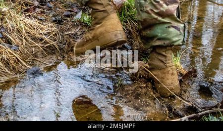 USA Army Sgt. 1. Klasse Larry May, ein Ausbilder der Kompanie B, 4. Bataillon, 399. Regiment, arbeitet sich während des Landschifffahrtstrainings am 19. März 2022 auf Fort Knox durch einen Fluss. Ky. Soldaten von 4. Mrd., 399. Regt., die als Kadett-Sommerkurslehrer dienen, absolvierten ein Auffrischungstraining für Landnavigation, bevor sie den Kurs überquerten, um ihre angegebenen Punkte während der Kampfversammlung im März zu finden. Stockfoto