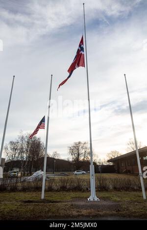 USA Marines und norwegische Soldaten setzen ihre Flaggen auf Halbmast für eine Zeremonie während der Übung Cold Response 2022, Vaernes, Norwegen, 20. März 2022. Die Marines, die der Arrival and Assembly Operations Group, der II Marine Expeditionary Force und der norwegischen Heimatwache zugeteilt wurden, boten die Gelegenheit, die Marines zu ehren, die bei einem Ausbildungsunfall in Nordnorwegen verloren gingen, indem neben ihnen eine amerikanische Flagge gehisst wurde. Übung Cold Response '22 ist eine alle zwei Jahre stattfindende norwegische nationale Bereitschafts- und Verteidigungsübung, die in ganz Norwegen stattfindet, mit Beteiligung jedes seiner Militärs Stockfoto