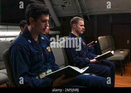 SEELEUTE DER PHILIPPINEN SEE (20. März 2022) singen während eines Gottesdienstes in der Kapelle an Bord der USS Abraham Lincoln (CVN 72) Hymnen. Die Abraham Lincoln Strike Group befindet sich in einem geplanten Einsatz im US-7.-Flottenbereich, um die Interoperabilität durch Allianzen und Partnerschaften zu verbessern und gleichzeitig als einsatzbereite Truppe zur Unterstützung einer freien und offenen Region Indo-Pacific zu fungieren. Stockfoto