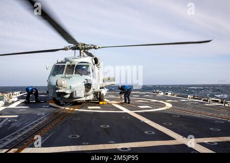 NORWEGISCHE SEE (21. März 2022) Boatswain’s Mate Seaman Armando Herrera, Left, und Boatswain’s Mate Seaman Pablo Garciamedina entfernen Keile und Ketten aus einem MH-60R Seahawk Hubschrauber, der am Helicopter Maritime Strike Squadron (HSM) 79 2022 befestigt ist, an Bord der Arleigh Burke-Klasse Guided-Roosile Destrovyer, USS 80. März 21. Roosevelt, nach Rota, Spanien, stationiert, ist auf seiner dritten Patrouille in den USA Sechster Einsatzbereich der Flotte zur Unterstützung regionaler Verbündeter und Partner sowie nationaler Sicherheitsinteressen der USA in Europa und Afrika. Stockfoto