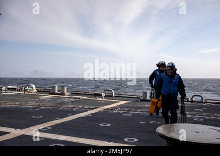 NORWEGISCHE SEE (21. März 2022) Boatswain’s Mate Seaman Pablo Garciamedina, Front und Boatswain’s Mate Seaman Armando Herrera tragen Keile und Ketten an Bord des Arleigh Burke-Class Guided-Missile Destroyer USS Roosevelt (DDG 80), 21. März 2022. Roosevelt, nach Rota, Spanien, stationiert, ist auf seiner dritten Patrouille in den USA Sechster Einsatzbereich der Flotte zur Unterstützung regionaler Verbündeter und Partner sowie nationaler Sicherheitsinteressen der USA in Europa und Afrika. Stockfoto