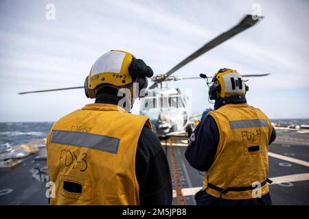 NORWEGISCHE SEE (21. März 2022) Boatswain’s Mate 3. Class Marlon Kalaw, Left und Boatswain’s Mate 3. Class Clifford Turner helfen bei der Inbetriebnahme eines MH-60R Seahawk Hubschraubers, angeschlossen an Helicopter Maritime Strike Squadron (HSM) 79 2022, an Bord des Arleigh Burke-Class Guided-Missile Destroyer USS Roosevelt, 21. März 80. Roosevelt, nach Rota, Spanien, stationiert, ist auf seiner dritten Patrouille in den USA Sechster Einsatzbereich der Flotte zur Unterstützung regionaler Verbündeter und Partner sowie nationaler Sicherheitsinteressen der USA in Europa und Afrika. Stockfoto