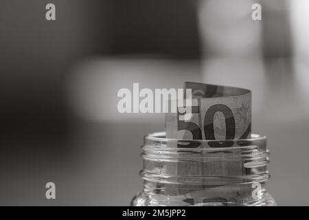 Komposition mit Spargeld-Banknoten (50 EURO) in einem Glasgefäß. Konzept der Investition und halten Geld, Nahaufnahme isoliert. Stockfoto