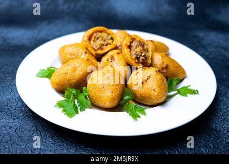 Traditionelle türkische Küche: „Ili kofte“, gebratener Bulgur und Hackfleisch. Kibaver oder kibbe. Stockfoto