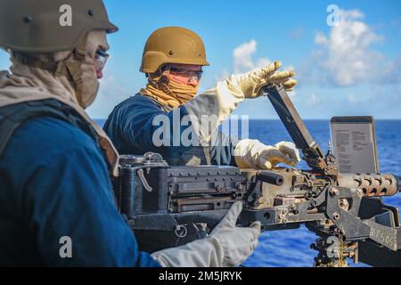 PHILIPPINE SEA (20. März 2022) Gunner's Mate 2. Class Denis Medved, aus Mechanicsville, Md., Front, and Fire Controlman 1. Class Joseph Reed, aus Arlington, Virginia, laden Sie ein Maschinengewehr mit 50 Kaliber während einer Feuerübung als Teil einer Schulung für fortgeschrittene Taktik der Oberflächenkriegsführung nach. Green Bay, Teil der Expeditionary Strike Group 7, ist zusammen mit der 31. Marine Expeditionary Unit (MEU) im Zuständigkeitsbereich der US-amerikanischen 7.-Flotte tätig, um die Interoperabilität mit Verbündeten und Partnern zu verbessern und als einsatzbereite Eingreiftruppe zur Verteidigung von Frieden und Stabilität in der Region Indo-Pazifik zu dienen. Stockfoto