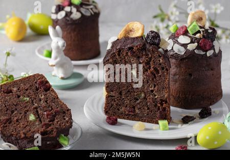 Schokoladen-Osterkuchen mit kandierten Früchten auf grauem Hintergrund. Osterfrühling-Stillleben Stockfoto