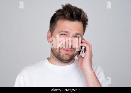 Junger Kaukasier, der mit dem Handy spricht. Stockfoto