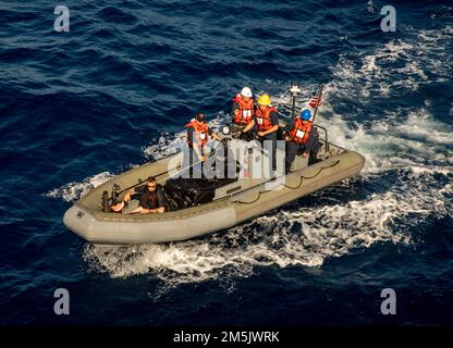 SÜDCHINESISCHES MEER (12. März 2022) Seeleute an Bord eines aufblasbaren Starrhull Boats (RHIB) kehren zurück zum Arleigh-Burke-Klasse-Guided-Missile Destroyer USS Ralph Johnson (DDG 114). Ralph Johnson ist der Task Force 71/Destroyer Squadron (DESRON) 15, dem größten nach vorn verlegten DESRON der Marine, und der Hauptstreitkraft der US-7.-Flotte zugewiesen. Stockfoto