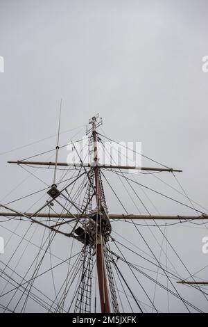Masten auf einem Hochsee-Segelschiff befestigen. Der Mast fotografierte vor einem bewölkten Himmel Stockfoto