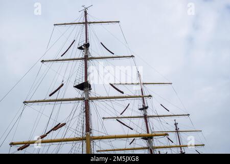 Masten auf einem Hochsee-Segelschiff befestigen. Der Mast fotografierte vor einem bewölkten Himmel Stockfoto