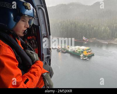 Petty Officer 3. Class Christopher Daniel, ein Flugzeugwartungstechniker an der Air Station Sitka, beobachtet einen Ölschauer rund um den Western Mariner, einen 83 Meter inspizierten Schlepper, in der Neva Strait, 21. März 2022. Der westliche Mariner rannte auf Grund, während er Chichagof Provider, einen 286 Meter langen Container-Lastkahn in der Neva-Straße, schleppte. Es wurden keine Verletzungen gemeldet und alle Kraftstoffverteiler an Bord des Schleppers wurden gesichert, um den bersten Tank zu isolieren. Es wurde ein einheitliches Kommando eingerichtet, bestehend aus der Küstenwache, dem Alaska Department of Environmental Conservation und dem westlichen Schleppboot. USA Foto der Küstenwache von Haustier Stockfoto