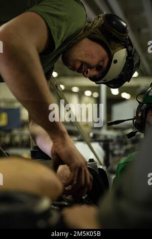 ATLANTIK - CPL. Wyatt Kazarian, ein Fluglinienmechaniker, der der 22. Marine Expeditionary Unit zugeteilt ist, demontiert einen AH-1Z Viper Hubschrauberrotor für eine Inspektion an Bord des Amphibienschiffs USS Kearsarge (LHD 3), 21. März 2022. Die Kearsarge Amphibious Ready Group mit 22. MEU ist auf einem geplanten Einsatz im US-Flottengebiet 2. Stockfoto