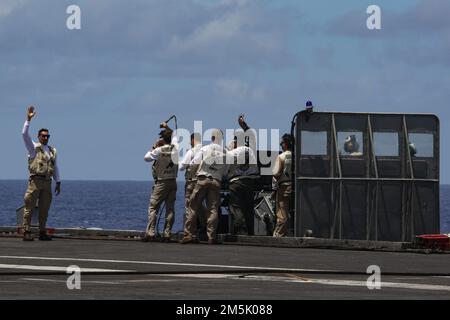 PHILIPPINE SEA (21. März 2022) Landing Signal Officers beobachten den Flugbetrieb auf dem Cockpit des Flugzeugträgers der Nimitz-Klasse USS Abraham Lincoln (CVN 72). Die Abraham Lincoln Strike Group befindet sich in einem geplanten Einsatz im US-7.-Flottenbereich, um die Interoperabilität durch Allianzen und Partnerschaften zu verbessern und gleichzeitig als einsatzbereite Truppe zur Unterstützung einer freien und offenen Region Indo-Pacific zu fungieren. Stockfoto