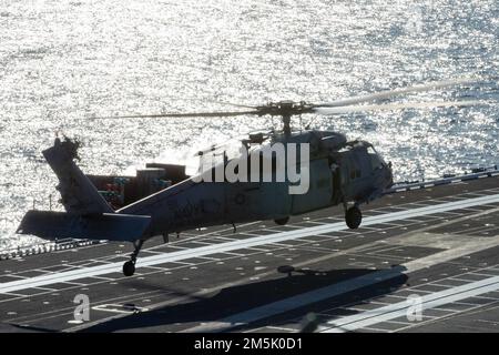 Ein MH-60s Nighthawk, der den „Tridents“ des Helicopter Sea Combat Squadron (HSC) 9 beigefügt ist, nähert sich dem Flugdeck von USS Gerald R. Ford (CVN 78), 21. März 2022. Ford führt im Atlantik im Rahmen der auf das Schiff zugeschnittenen Grundphase vor dem Einsatz die Zertifizierung des Cockpits und die Qualifikation von Luftfahrtunternehmen durch. Stockfoto