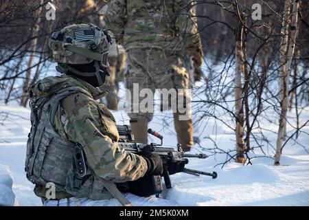 EIN US-AMERIKANISCHER Army Infantryman, 3. Bataillon, 21. Infanterie-Regiment, 1. Stryker-Brigade-Kampfteam, 25. Infanterie-Division, USA Armee Alaska führt die M249. Einheit Automatik-Waffe (SAW) auf Patrouille während des Joint Pacific Multinational Readiness Center 22-02 nahe Ft. Greely, AK, 21. März 2022. Ein Team von Teams benötigt eine Übung wie JPMRC 22-02, die ein breites Spektrum an Erfahrung und Fähigkeiten erfordert, um eine groß angelegte Übung sicher unter arktischen Winterbedingungen durchzuführen. Stockfoto