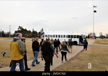 Teilnehmer an einem Community Leader Engagement steigen am 21. März 2022 vor dem Hauptquartier von Garrison in Fort McCoy, Wisconsin, in einen Bus ein. Mehr als ein Dutzend Gemeindeführer aus Tomah, Sparta, Black River Falls, La Crosse und anderen nahegelegenen Gemeinden haben sich in Fort McCoy versammelt, um die Mission der Post aus erster Hand zu sehen. Während ihres Besuchs erhielten die Führer der Gemeinde eine Fahrt durch die Anlage und machten Halt an der Combined Arms Collective Training Facility auf der South Post, Fort McCoy Commemorative Area, Fort McCoy Simulations Training Complex im 200. Block im Kantonment, Garrison Headqu Stockfoto