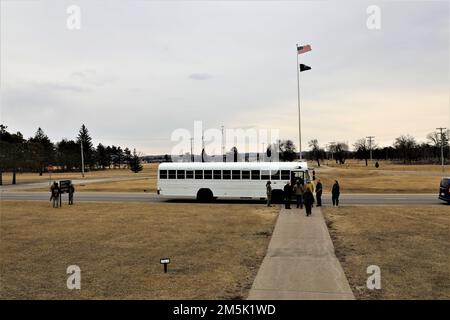 Teilnehmer an einem Community Leader Engagement steigen am 21. März 2022 vor dem Hauptquartier von Garrison in Fort McCoy, Wisconsin, in einen Bus ein. Mehr als ein Dutzend Gemeindeführer aus Tomah, Sparta, Black River Falls, La Crosse und anderen nahegelegenen Gemeinden haben sich in Fort McCoy versammelt, um die Mission der Post aus erster Hand zu sehen. Während ihres Besuchs erhielten die Führer der Gemeinde eine Fahrt durch die Anlage und machten Halt an der Combined Arms Collective Training Facility auf der South Post, Fort McCoy Commemorative Area, Fort McCoy Simulations Training Complex im 200. Block im Kantonment, Garrison Headqu Stockfoto