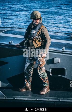 Ein Korps-Marinier mit dem Royal Netherlands Marine Corps bereitet sich auf das Andocken eines Landing Craft Vehicle Personnel (LCVP) während der Übung Cold Response 22 in Sandstrand, Norwegen, am 21. März 2022 vor. Übung Cold Response 22 ist eine alle zwei Jahre stattfindende norwegische nationale Bereitschafts- und Verteidigungsübung, die in ganz Norwegen stattfindet, an der sich alle seine Militärdienste, darunter 26 alliierte Nationen der Nordatlantikvertrags-Organisation (NATO) und regionale Partner, beteiligen. Stockfoto