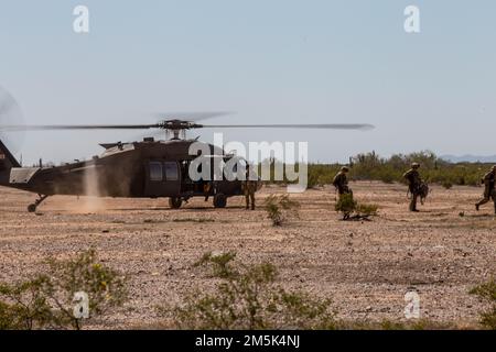 Die besten Krieger-Wettbewerber laden einen UH-60 Black Hawk während der Ariz. Herunter State Best Warrior Competition in Florence Military Reservation, in Florence, Arizona, 22. März 2022. Der AZNG-Wettbewerb „Bester Krieger“ ist eine spezialisierte Veranstaltung, bei der eine Reihe von „Soldier Skills“-Bewertungen durchgeführt werden, bei denen die Bürgersoldaten aus unseren verschiedenen Gemeinden getestet und ausgebildet werden Stockfoto