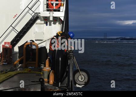 USA Coast Guard Petty Officer 2. Class James Preble, ein Boatswain's Mate an Bord von Coast Guard Cutter Spar, positioniert einen Kotflügel über der Seite des Schiffes, um in Quebec City, Kanada, am 21. März 2022 anzulaufen. Spar und ihre Crew reisen nach Duluth, Minn. nach einer einjährigen Wartungszeit in Baltimore. Stockfoto