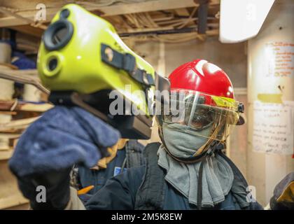 PHILIPPINE SEA (21. März 2022) Damage Control Fireman Aaliyah Jerrick aus Fayetteville, North Carolina, überprüft während einer Feuerübung im Schließfach der Kameraden des Arleigh-Burke-geführten Raketenzerstörers USS Higgins (DDG 76) auf Wärmesignaturen. Higgins ist dem Befehlshaber der Task Force (CTF) 71/Destroyer Squadron (DESRON) 15, der größten nach vorn eingesetzten DESRON der Marine und der Hauptstreitkräfte der US-7.-Flotte zugewiesen. Stockfoto