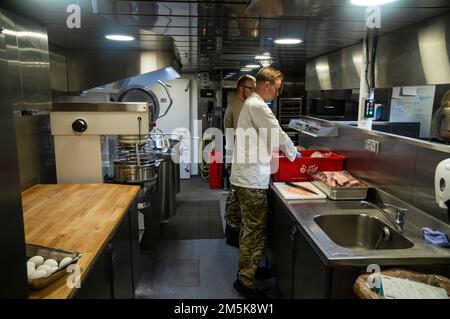 Zubereitung von Essen in der Küche des Patrouillenschiffs der Königlichen dänischen Marine HDMS Triton während der Operation Nanook 2022. Stockfoto