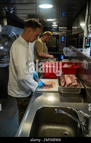 Zubereitung von Essen in der Küche des Patrouillenschiffs der Königlichen dänischen Marine HDMS Triton während der Operation Nanook 2022. Stockfoto