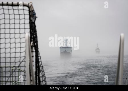 HDMS Triton und USCGC Bear folgen HMCS Margaret Brooke im Nebel aus dem Hafen von Halifax zu Beginn der Operation Nanook 2022. Stockfoto