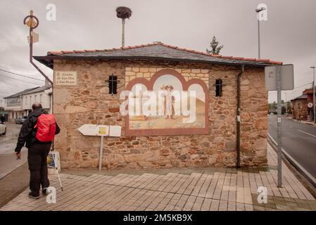 Vorbeifahrende Pilger: Die mittelalterliche kleine Kapelle auf der Saint James Way, die Ermita de San Blas y San Roque am Stadtrand von Ponferrada, heute zwischen modernen Straßen. Stockfoto