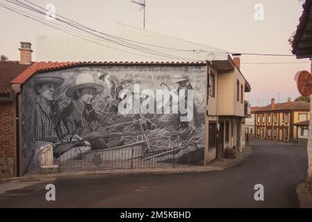 Wandgemälde im Dorf Villar de Mazarife entlang des Saint James Way, auf dem Bauarbeiter während der Ernte auf einem Feld dargestellt werden. Stockfoto